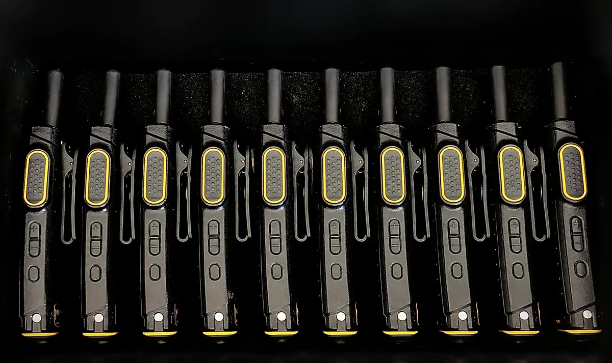 Ten compact Master System radios lined up in a black foam case